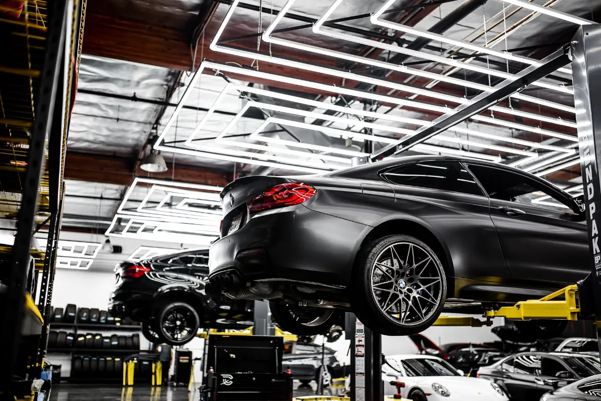 A modern car repair shop showcasing vehicles on lifts and a well-lit, organized interior