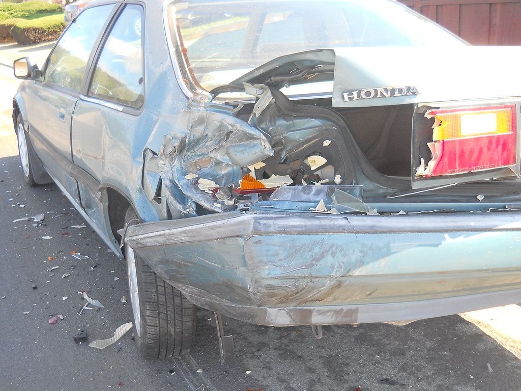 Totaled sedan with a crushed rear end after a crash, the situation where gap insurance and negative equity matter