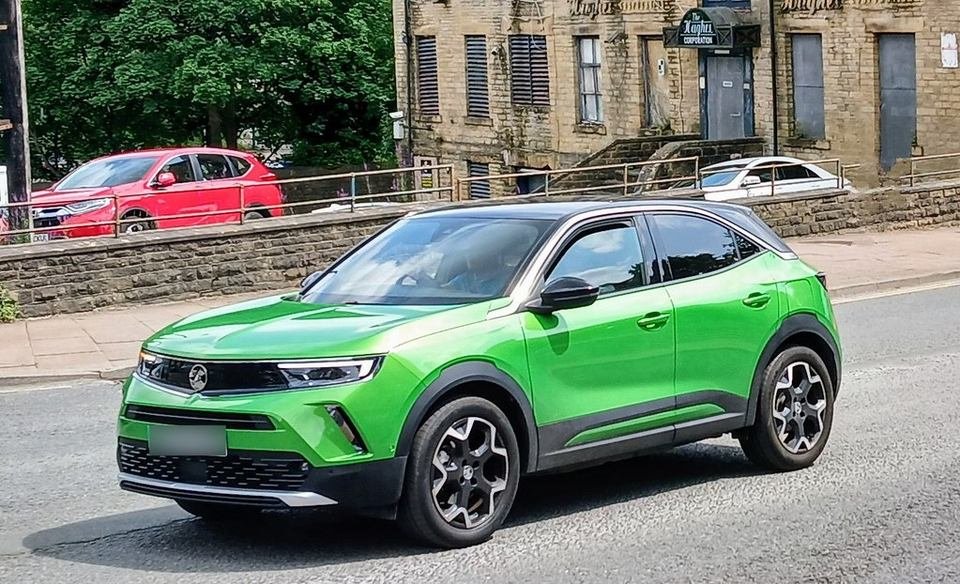 Modern compact car on a city street; hybrid battery replacement is one of the biggest repair bills on older hybrids