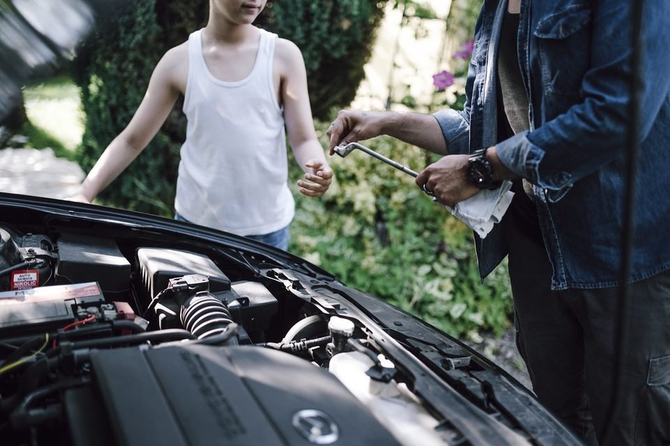 Mechanic working in an open engine bay near the intake manifold