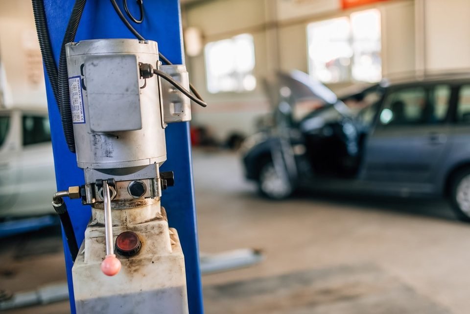 Car lift in a repair shop, used for labor-heavy jobs like an oil pump replacement