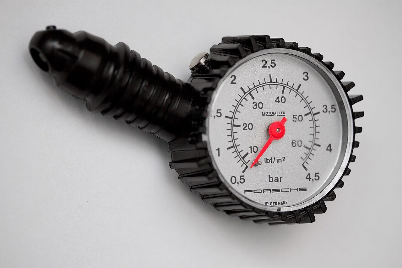 Checking tire pressure on a car wheel