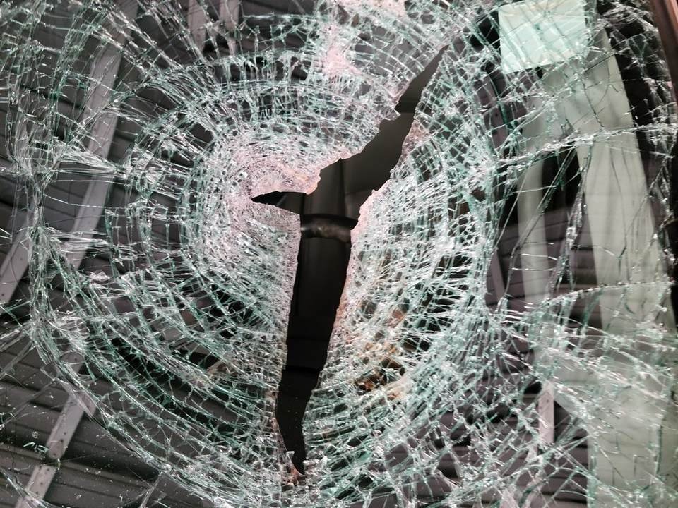 Cracked windshield glass; small chips are cheap to repair before they spread like this